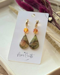 A pair of teardrop-shaped drop earrings with gold-tone hooks and orange crysta, featuring marbled green, beige, and brown stained glass drops