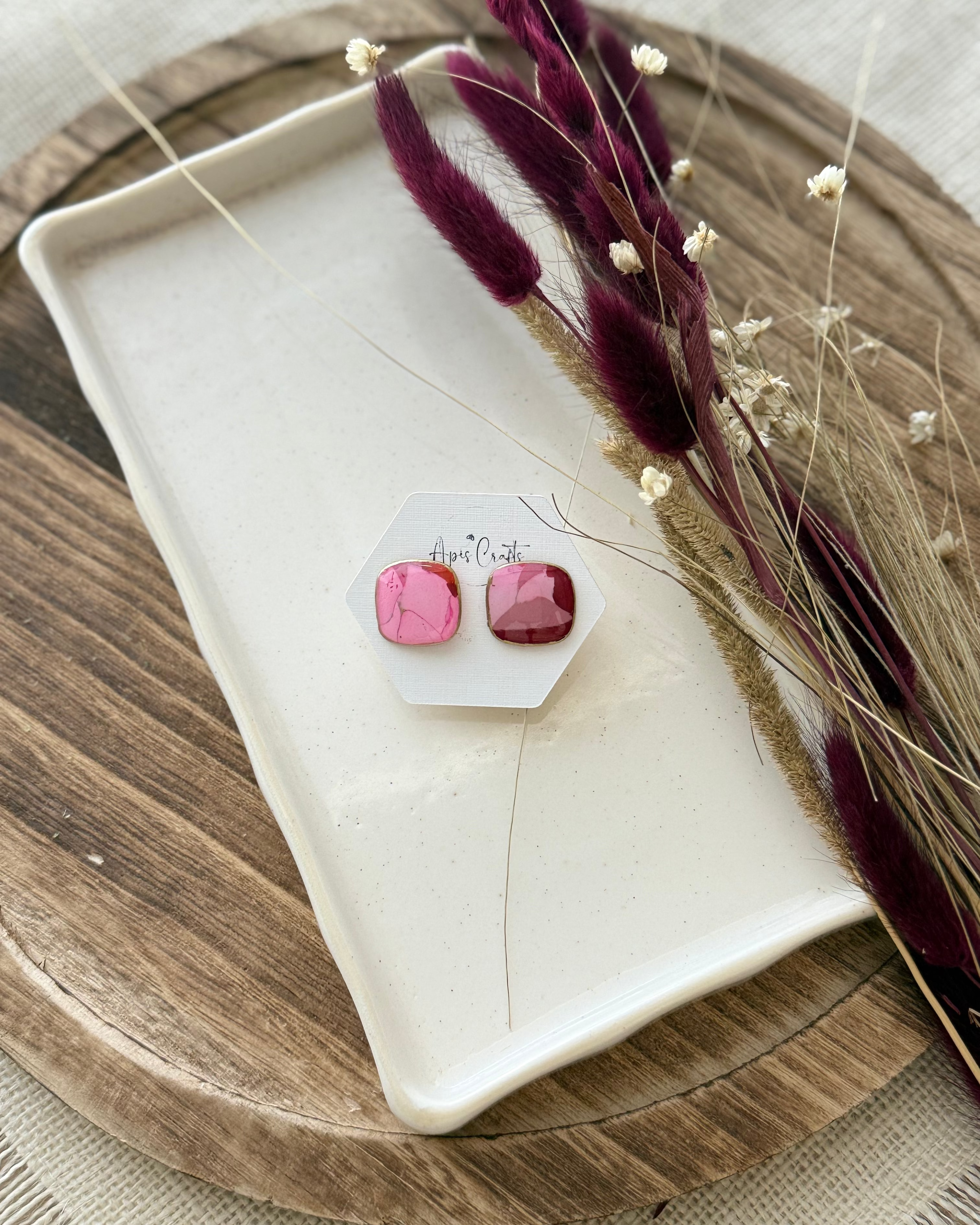 A pair of faux stone square stud earrings in pink and red