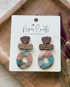 A pair of handmade geometric drop earrings featuring textured donut medallions