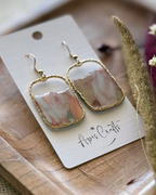A pair of gold-tone drop earrings with rectangular marbled pendants in soft pastel tones
