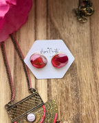 A pair of pebble shaped stud earrings with oval pink and red faux stone finish