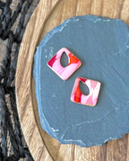 Diamond shaped charm with a teardrop keyhole in pink and red faux stone
