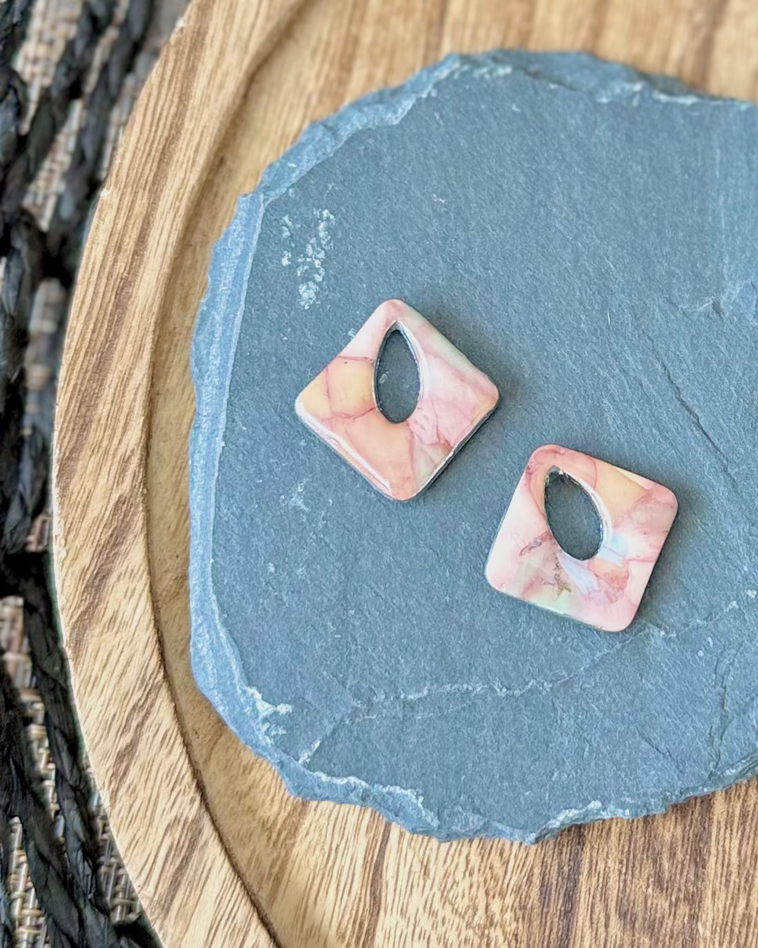 Diamond shaped charm with a teardrop keyhole in a pink and sand limestone