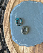 Two small teardrop-shaped stone beads with holes, one black and one jade